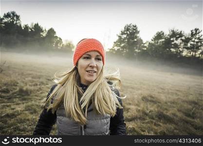Woman on misty open field, Augsburg, Bavaria, Germany