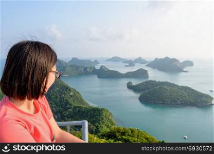 Woman on peak looking beautiful nature. Woman tourist on the balcony is peak view point of Ko Wua Ta Lap island looking beautiful nature landscape during sunrise over the sea in Mu Ko Ang Thong National Park, Surat Thani, Thailand