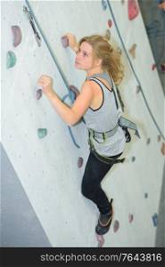 woman on rock climbing wall at the gym