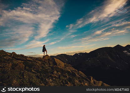 Woman on rocky outcrop looking at view, Rocky Mountain National Park, Colorado, USA