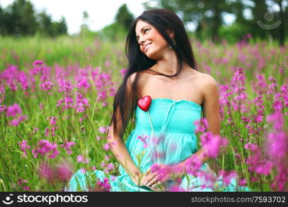 woman on summer flower field meadow heart in hands love nature. woman on flower field