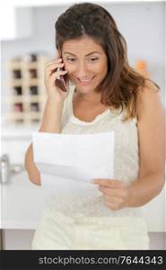 woman on telephone passing on good news received by letter