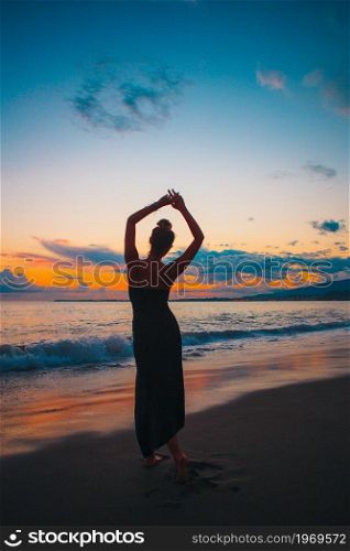 Woman on the beach enjoying summer holidays looking at the sea. Young woman on the beach at sunset