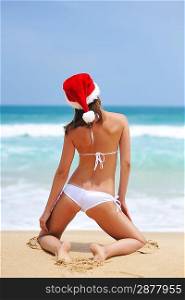 Woman on the beach in santa&acute;s hat