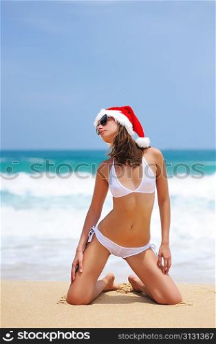 Woman on the beach in santa&acute;s hat