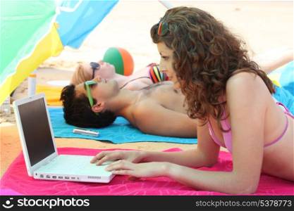 woman on the beach with laptop
