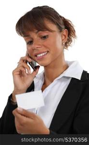 Woman on the phone looking at a business card