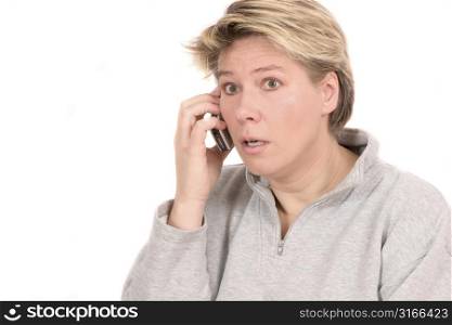 Woman on the phone looking totally shocked at the news she is hearing
