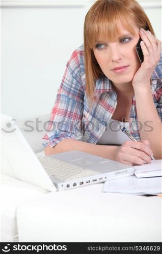 Woman on the phone working at a laptop