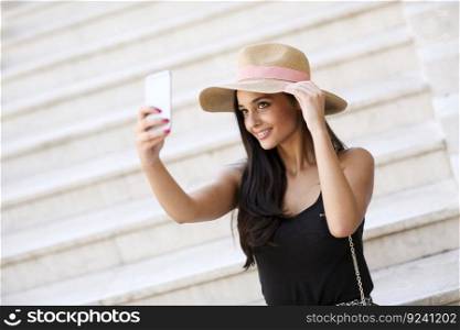 Woman on the stairs outside taking selfie