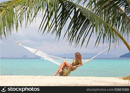 Woman on tropical beach. Beautiful young woman in bikini in hammock on tropical sea beach