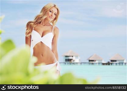woman on tropical beach house back on the background. woman on tropical beach