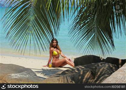 Woman on tropical beach. Woman in bikini sitting on tropical beach