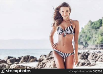 Woman on tropical beach. Woman in bikini walking on tropical beach