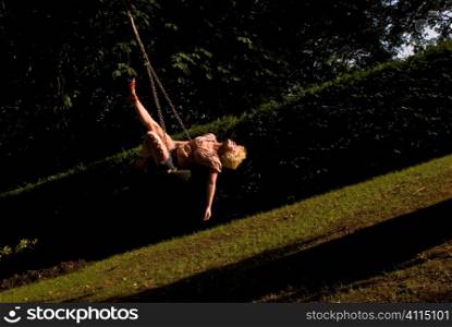 Woman on tyre swinging from tree