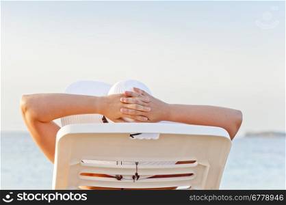 woman on vacation at the beach in a lounge chair