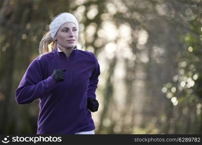 Woman On Winter Run Through Woodland