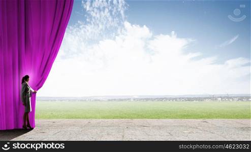 Woman opening curatin. Young businesswoman opening stage curtain to another reality