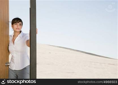 Woman opening door in desert