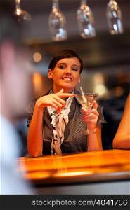 Woman ordering another drink at bar