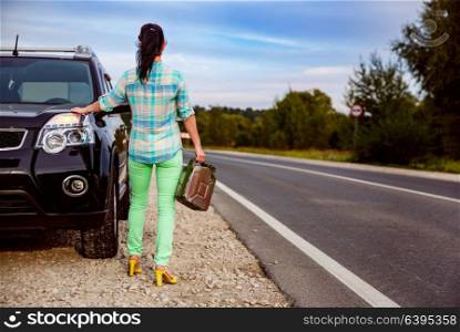 Woman out of gas standing by the road