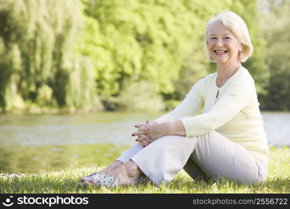 Woman outdoors at park by lake smiling