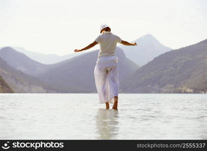 Woman outdoors walking on water in scenic location