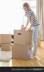 Woman packing cardboard box at home
