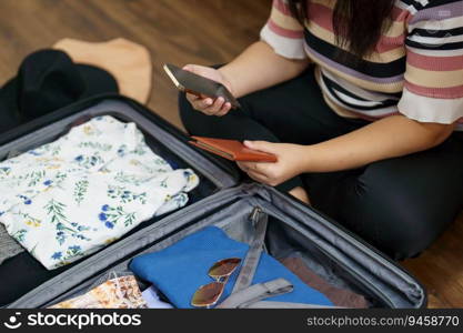 Woman packs bagga≥and passport in the suitcase prepared to travel≠w jour≠y packing a lugga≥travel plans vacation