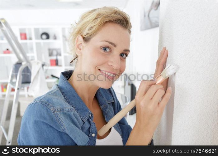 woman painter designer and worker paints a wall