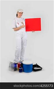 woman painter holding red panel for message