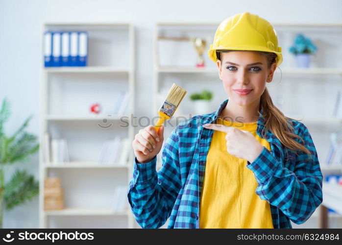 Woman painter with paintbrush in workshop