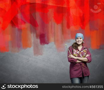 Woman painter. Young woman painter coloring wall with brush