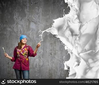 Woman painter. Young woman painter coloring wall with brush