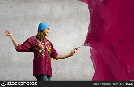 Woman painter. Young woman painter coloring wall with brush