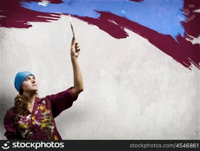 Woman painter. Young woman painter in bandana with paintbrush in hand