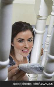 Woman painting behind banister
