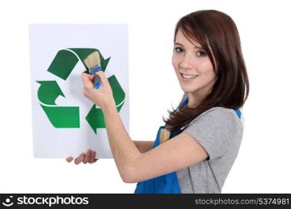Woman painting recycling symbol