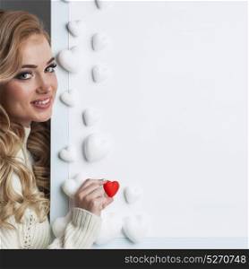 Woman painting red hearts. Young happy woman painting in red decorative hearts, Valentines day concept