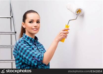 Woman painting the wall in DIY concept
