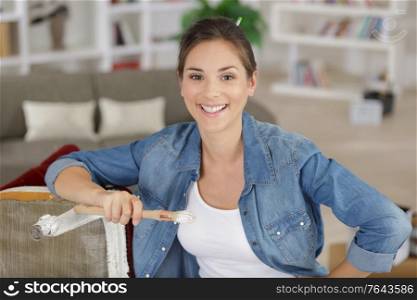 woman painting to renew chair at home