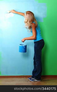 woman paints the wall brush