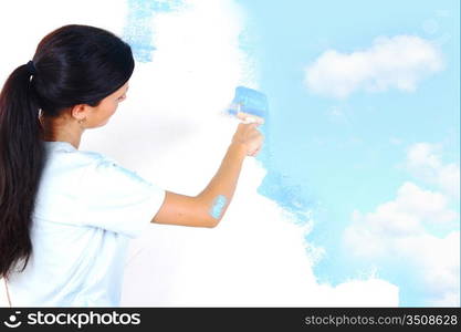 woman paints the wall brush