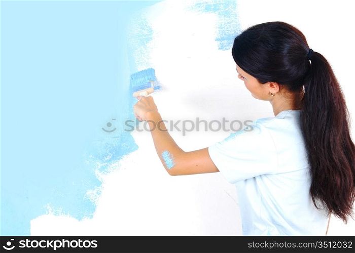 woman paints the wall brush