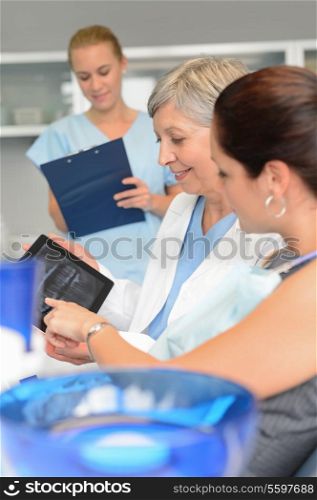 Woman patient at dental surgery point teeth xray tablet dentist