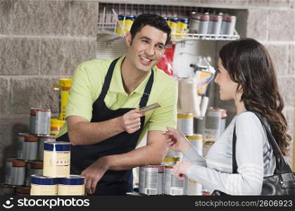 Woman paying by a credit card in a hardware store