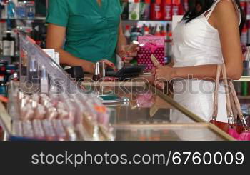 Woman paying for beauty care products at the cash counter