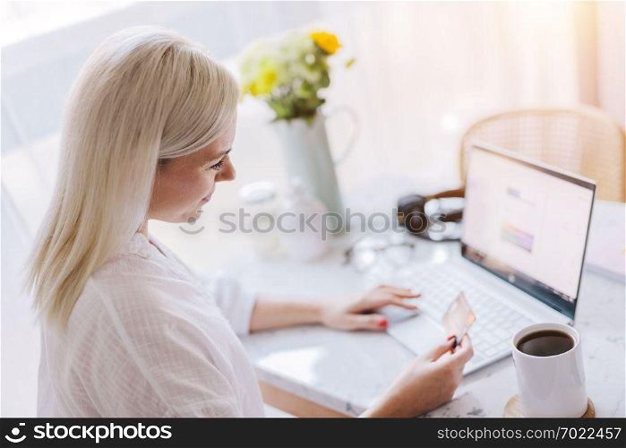 Woman paying online with her credit card, using laptop. Internet payments, online banking.. Woman paying online with her credit card.