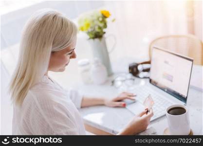 Woman paying online with her credit card, using laptop. Internet payments, online banking.. Woman paying online with her credit card.