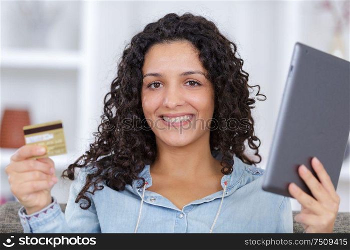 woman paying with a credit card on the tablet
